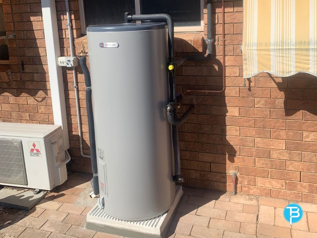 Hot water technician checking an outdoor tank in the Redlands